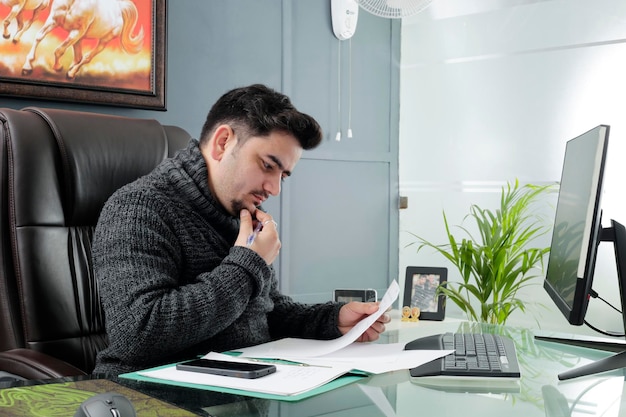 A person sitting at a desk, using a calculator and looking at financial documents, symbolizing careful financial planning.